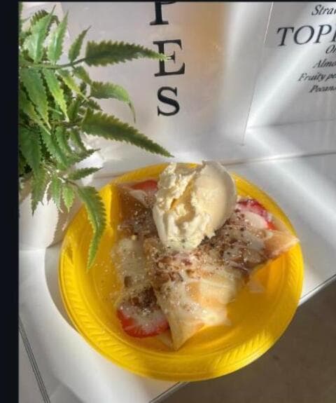 Sweet crepe with ice cream on a yellow plate